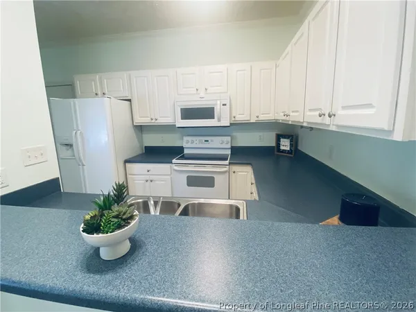 a kitchen with a white stove top oven and refrigerator