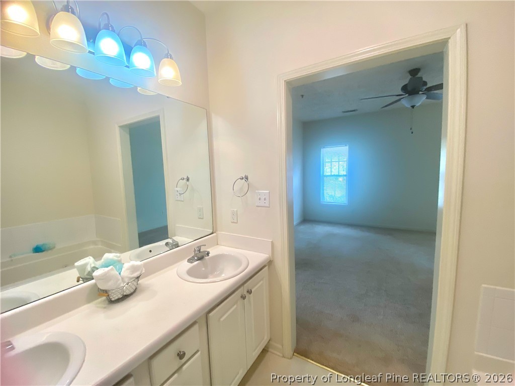 516 Lionshead Road, Unit 6 Fayetteville, NC 28311 - Photo 24 of 27 a bathroom with a granite countertop sink a toilet and a mirror