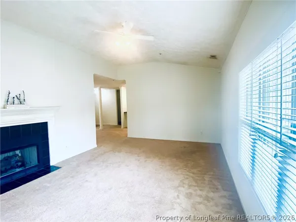 a view of an empty room with a fireplace and a window