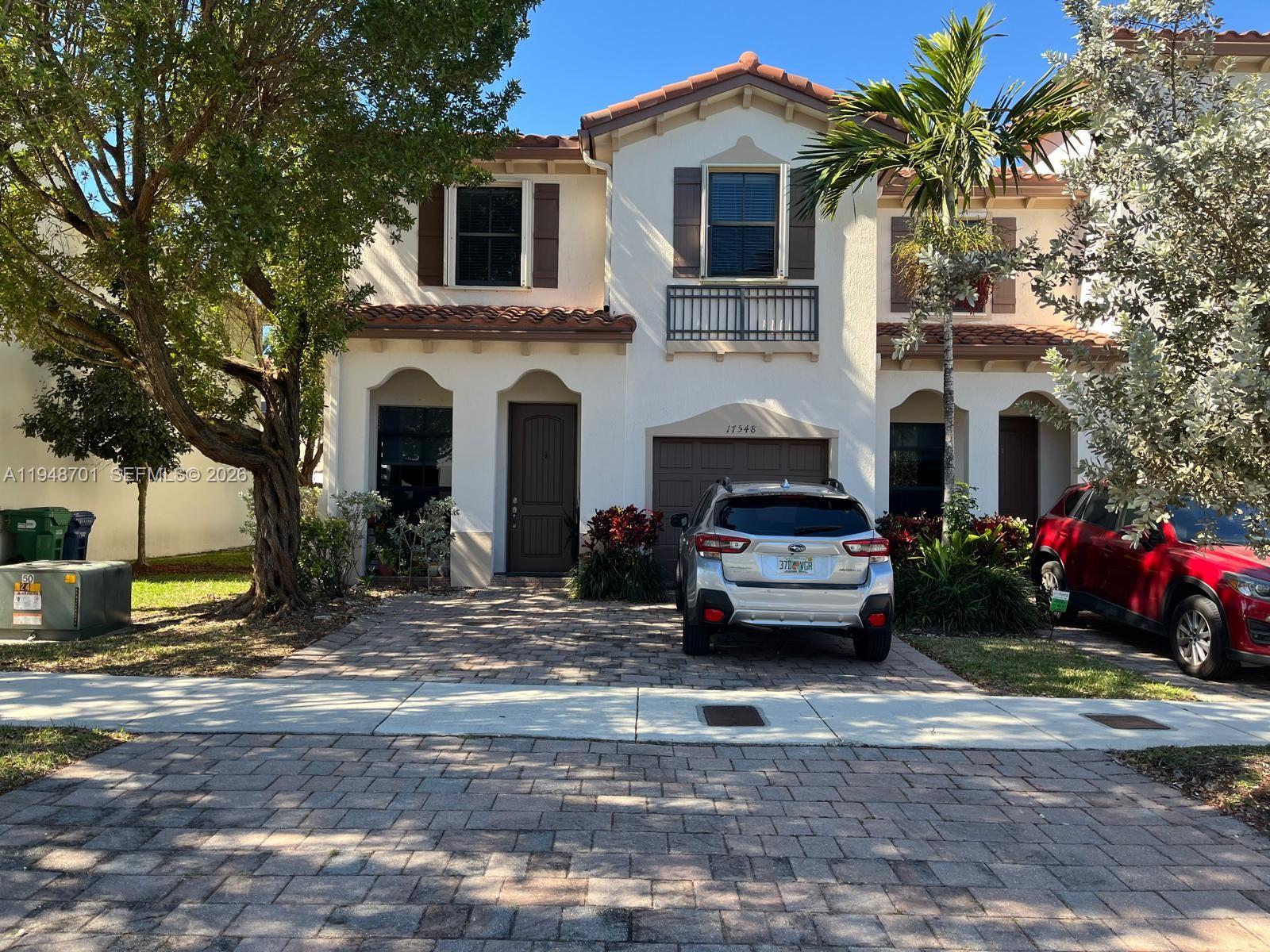 a car parked in front of a white house