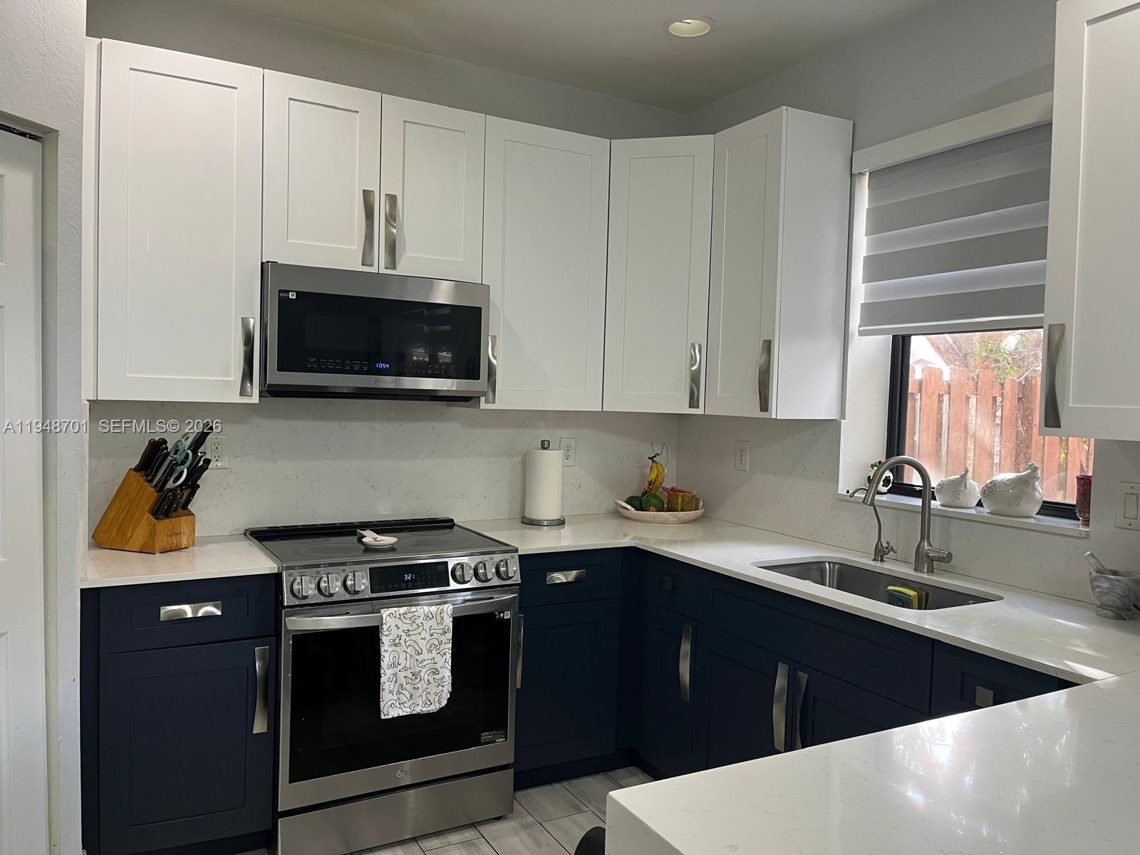 17548 Southwest 153rd Court Miami, FL 33187 - Photo 8 of 21 a kitchen with stainless steel appliances a stove a sink and a microwave