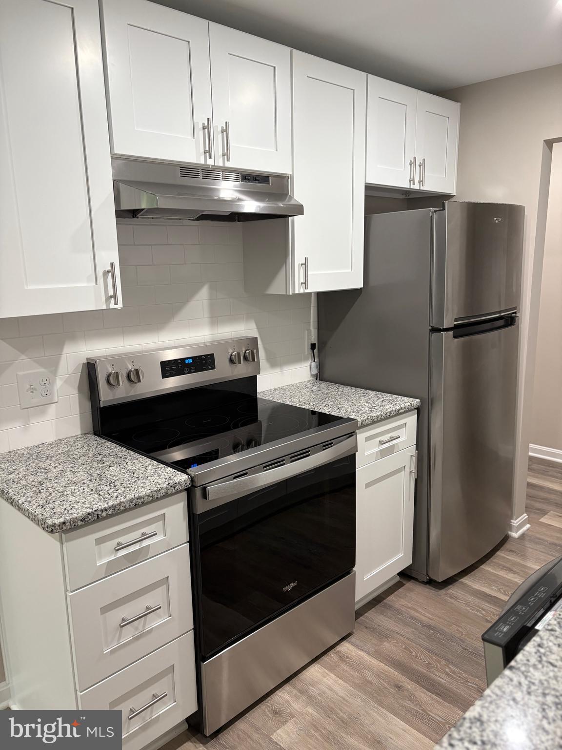 11611 Stoneview Square, Unit 70/12C Reston, VA 20191 - Photo 2 of 12 a kitchen with granite countertop white cabinets and stainless steel appliances