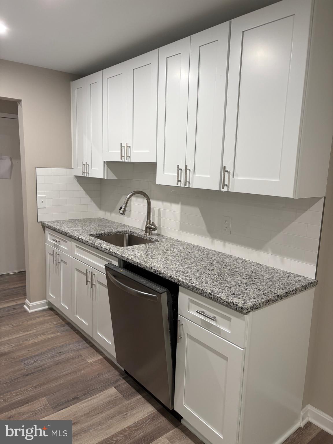 11611 Stoneview Square, Unit 70/12C Reston, VA 20191 - Photo 4 of 12 a kitchen with granite countertop white cabinets and sink