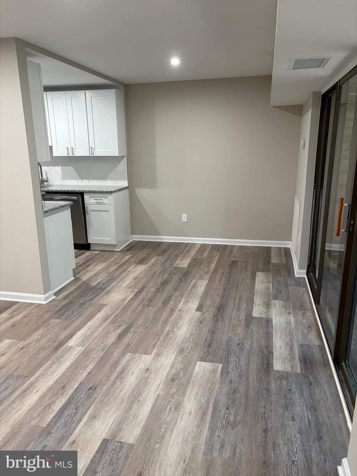 11611 Stoneview Square, Unit 70/12C Reston, VA 20191 - Photo 5 of 12 an empty room with wooden floor and a kitchen