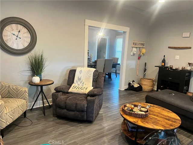 a living room with furniture a table and wooden floor