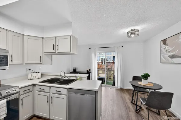 a kitchen that has a sink cabinets and wooden floor