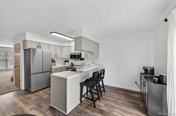 a kitchen with kitchen island a refrigerator stove and microwave