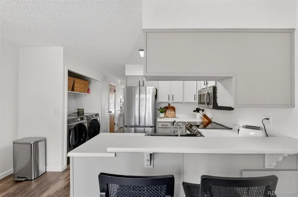 a kitchen with a sink a stove and chairs