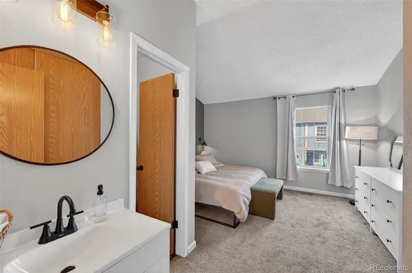 a spacious bedroom with a bed and a mirror