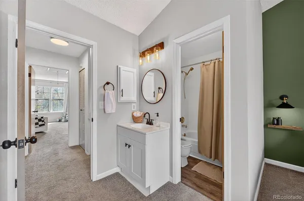 a view of a hallway with bathroom and wooden floor