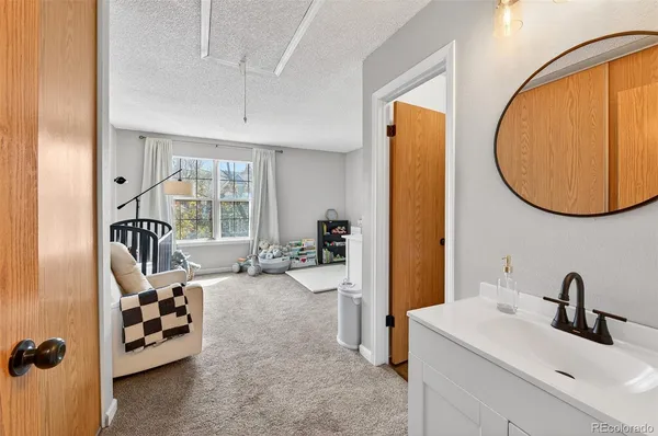 a view of a bedroom with a bed and a mirror