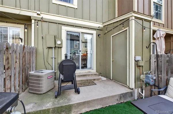 a view of a patio with chairs and a barbeque