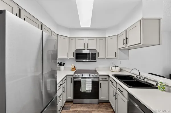 a kitchen with stainless steel appliances a stove a sink and a refrigerator