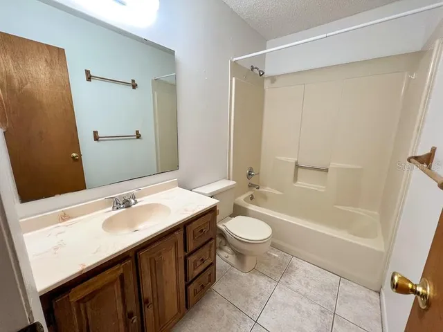 a bathroom with a sink a toilet a mirror and shower