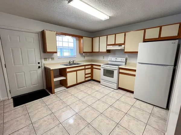a kitchen with stainless steel appliances granite countertop a refrigerator sink and stove