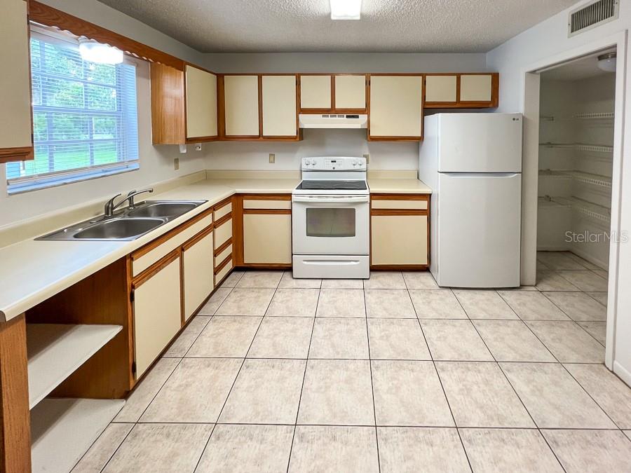 5601 Ave H, Unit 3 McIntosh, FL 32664 - Photo 10 of 21 a kitchen with a stove a refrigerator and a sink