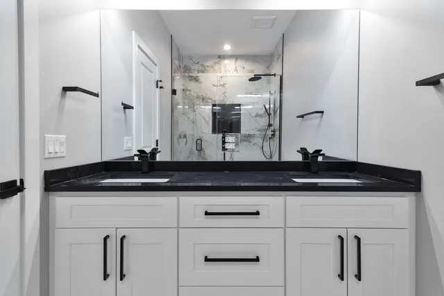 a bathroom with a granite countertop sink and a mirror