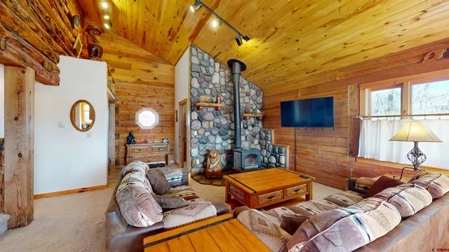 a living room with furniture a flat screen tv and a large window