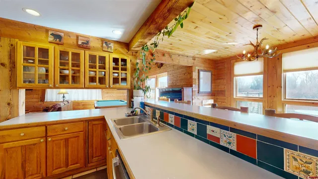 a large kitchen with stainless steel appliances a sink and cabinets