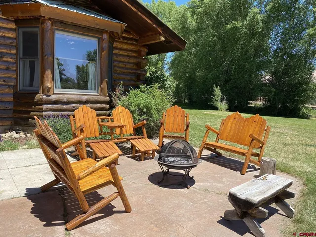 a view of a patio with table and chairs with wooden floor and fence