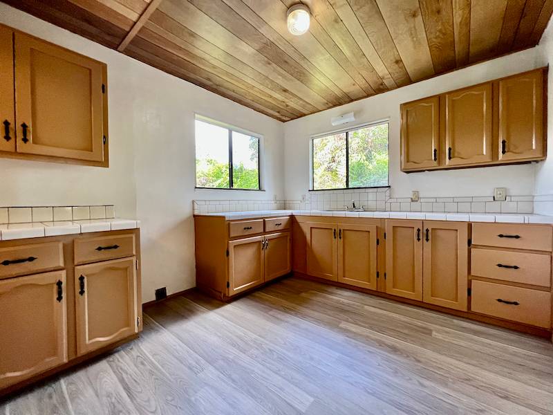 a kitchen with stainless steel appliances sink cabinets and wooden floor