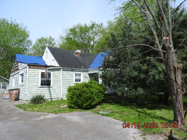 a view of a house with a yard and potted plants
