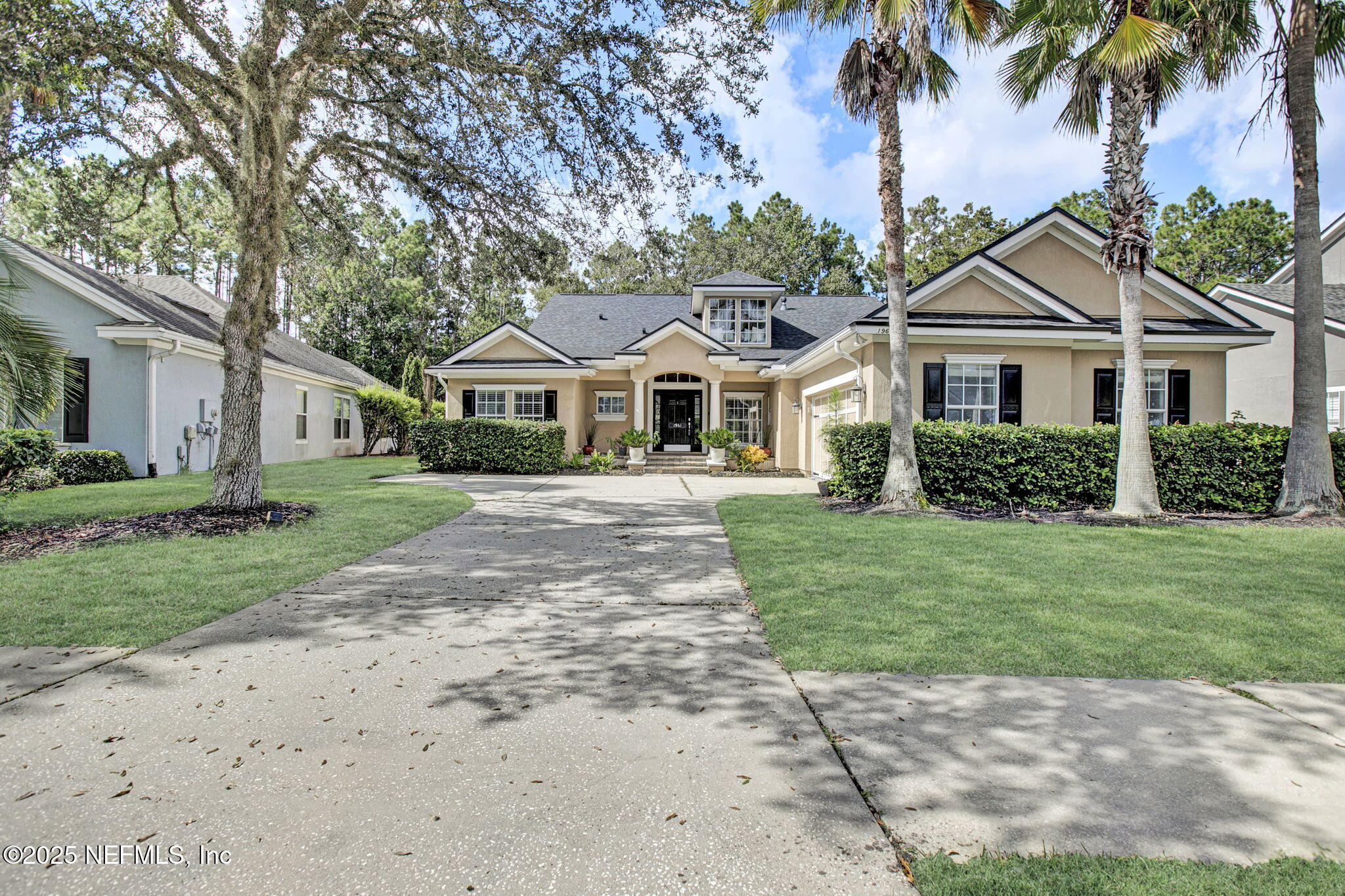 a front view of a house with a garden and trees