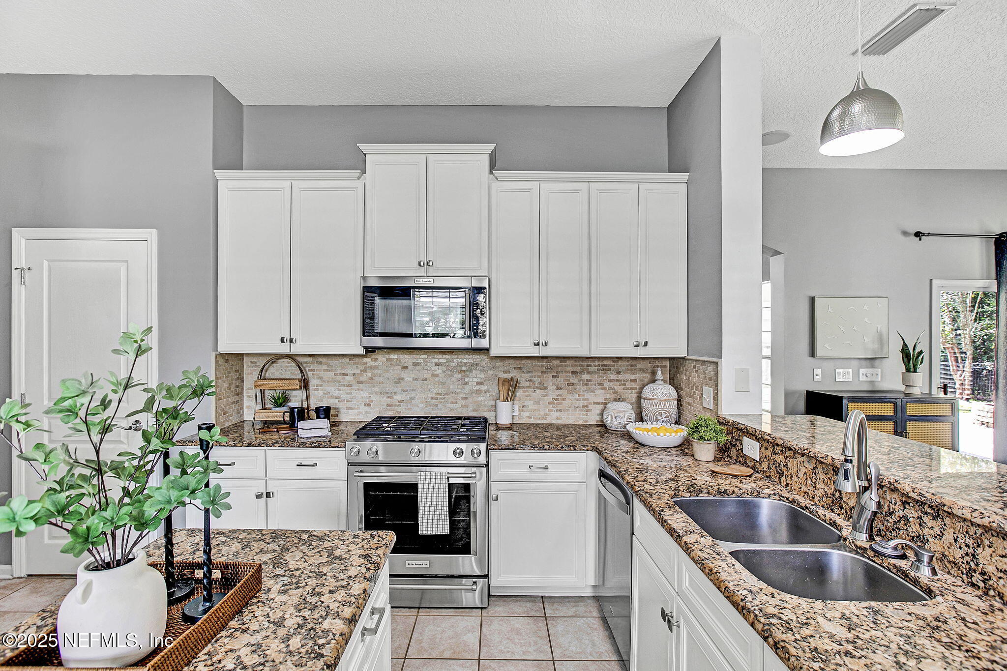 1961 Glenfield Crossing Court St. Augustine, FL 32092 - Photo 31 of 40 a kitchen with granite countertop a sink stove and cabinets