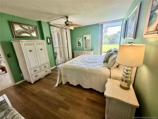 a bedroom with a bed a flat screen tv and dresser