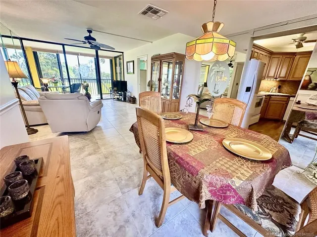 a view of a dining room with furniture a chandelier and wooden floor