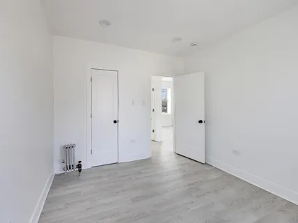 an empty room with wooden floor and window
