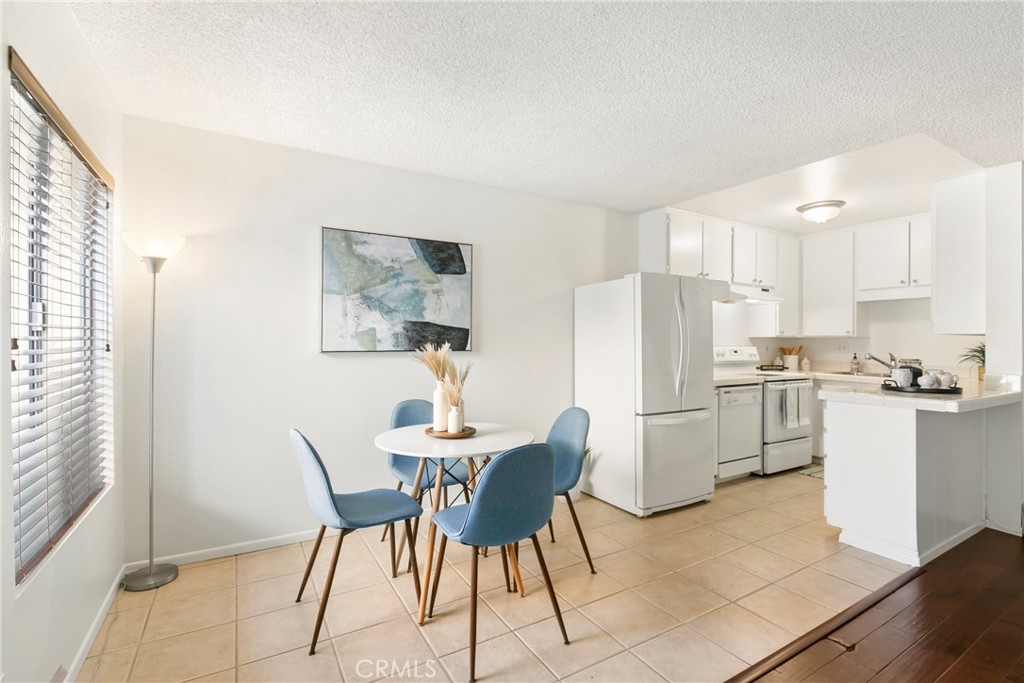 10472 Caminito Rimini San Diego, CA 92129 - Photo 11 of 27 a kitchen with a dining table chairs and refrigerator
