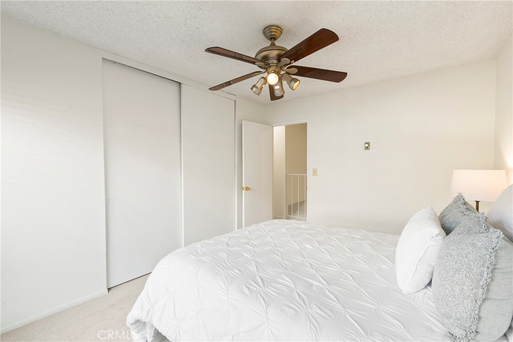 10472 Caminito Rimini San Diego, CA 92129 - Photo 16 of 27 a bedroom with a bed and a chandelier