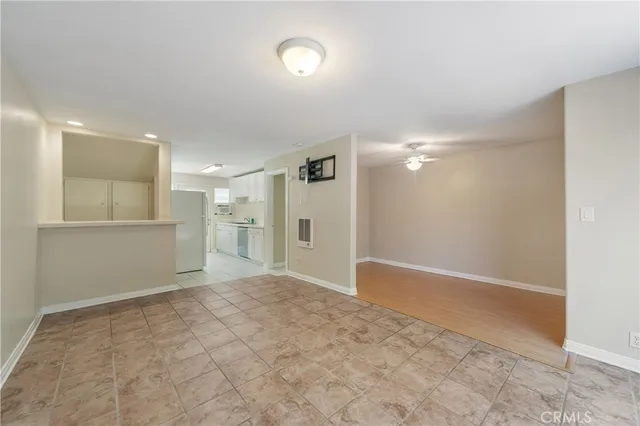 a view of an empty room and a kitchen