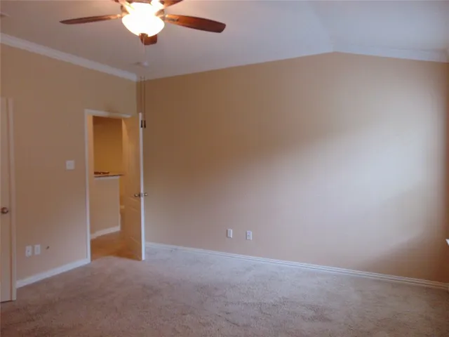 an empty room with a chandelier fan