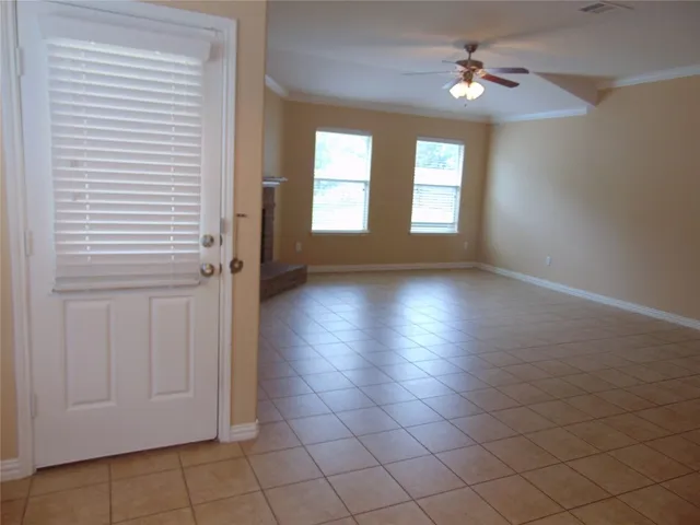 an empty room with windows and fan