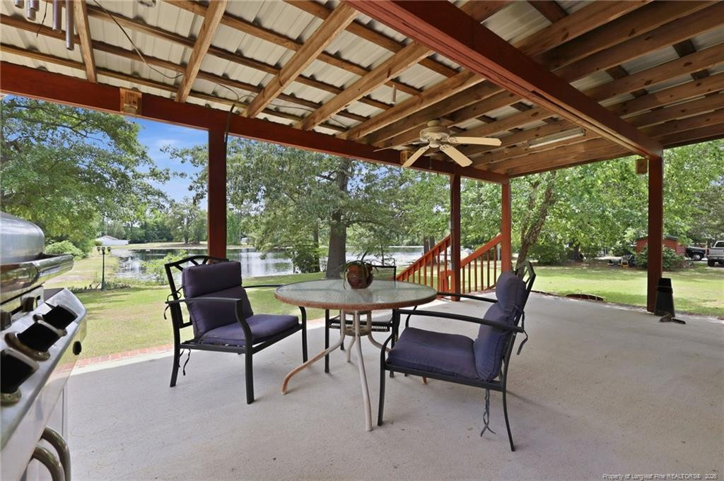 10400 Ruth Vinson Road Autryville, NC 28318 - Photo 19 of 49 a view of a patio with table and chairs potted plants with large tree