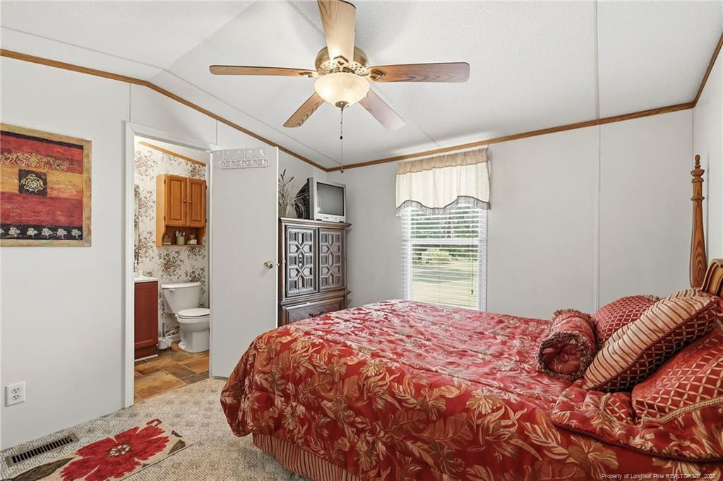 10400 Ruth Vinson Road Autryville, NC 28318 - Photo 44 of 49 a bedroom with a bed and a dresser in it