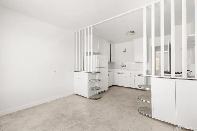 a kitchen with white cabinets and white appliances