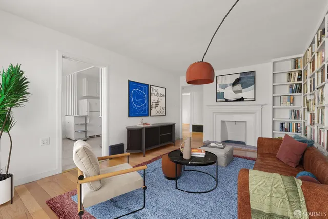 a living room with furniture a fireplace and a potted plant