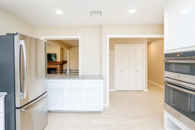 a view of living room with a refrigerator and a stove top oven