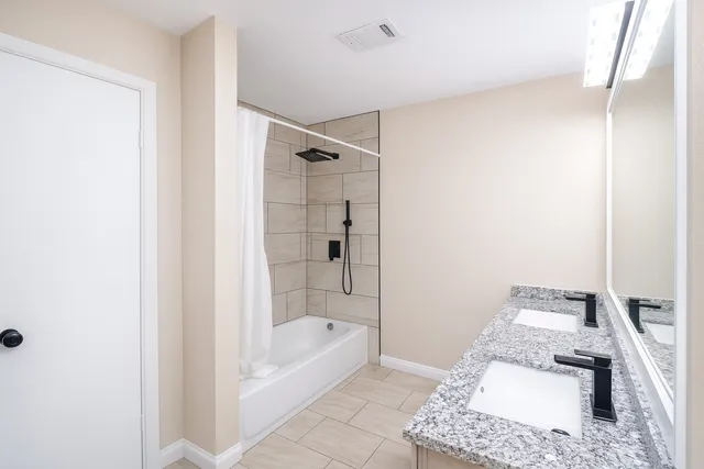 a bathroom with a tub shower and sink