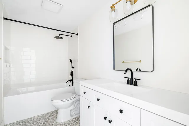 a bathroom with a sink a toilet and a mirror