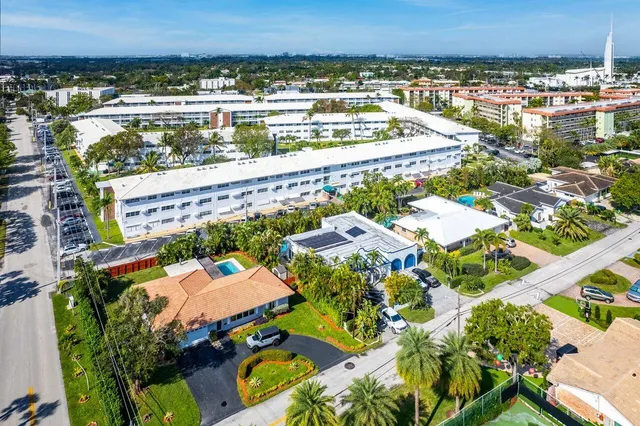 an aerial view of residential houses with outdoor space and ocean view