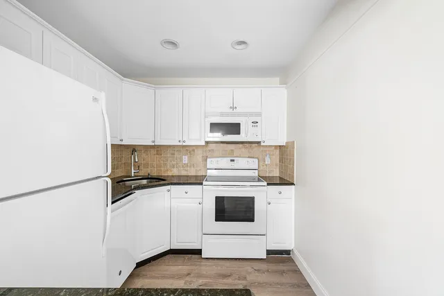 a kitchen with a stove top oven and white refrigerator