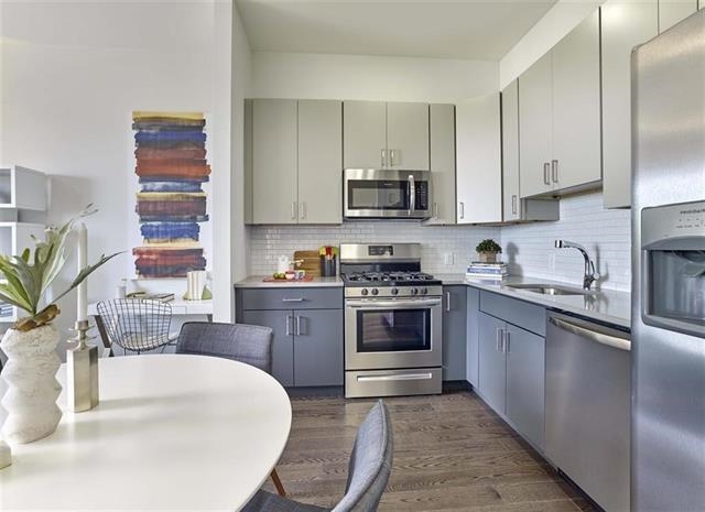 250 Ave East, Unit 609 Bayonne, NJ 07002 - Photo 3 of 17 a kitchen with stainless steel appliances granite countertop a sink stove and refrigerator
