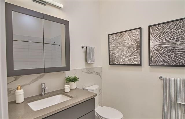 250 Ave East, Unit 609 Bayonne, NJ 07002 - Photo 5 of 17 a bathroom with a toilet sink and mirror