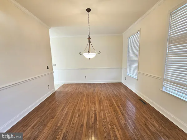 a view of a room with wooden floor and a ceiling fan