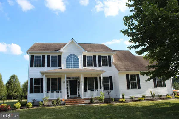 a front view of a house with a garden and plants