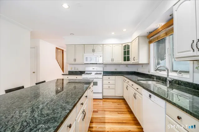 a large kitchen with granite countertop a sink and dishwasher with a granite countertops next to a window